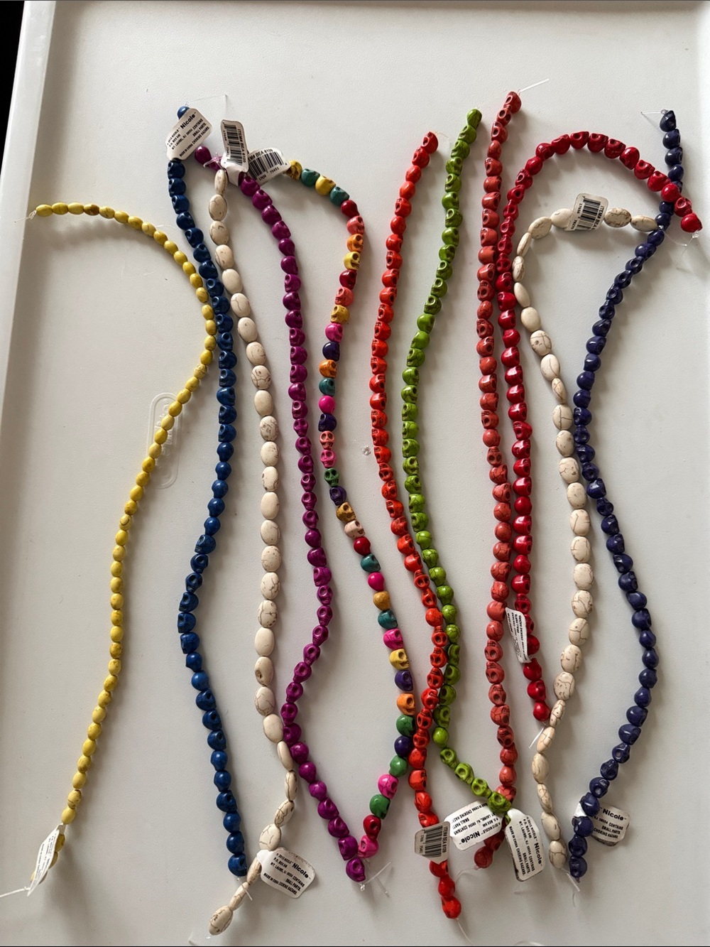 Assorted bead strands 
3 are plain, 8-skulls 
11 total.